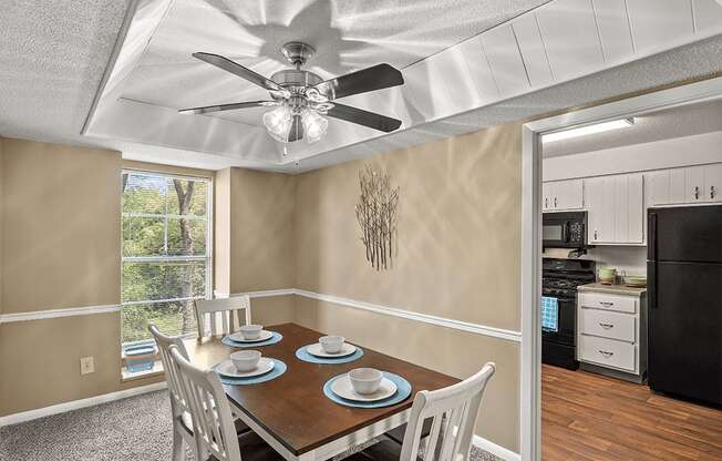 a dining room with a table and chairs and a ceiling fan