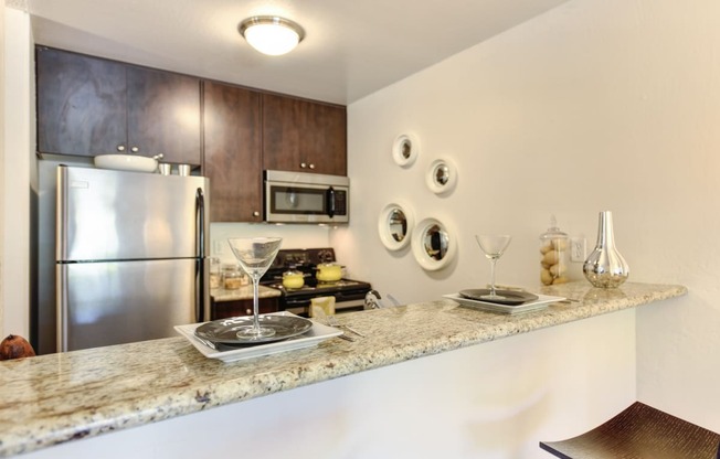 a kitchen with granite countertops and stainless steel appliances