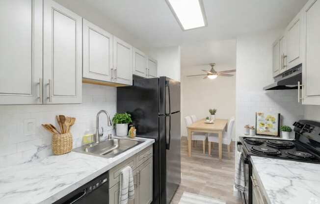 A kitchen with black appliances and white cabinets.