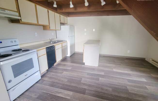a kitchen with white appliances and a wooden floor
