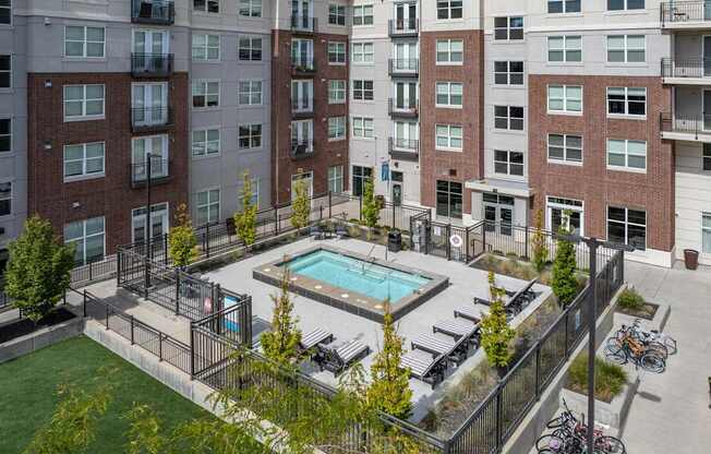 an aerial view of a swimming pool in front of an apartment building