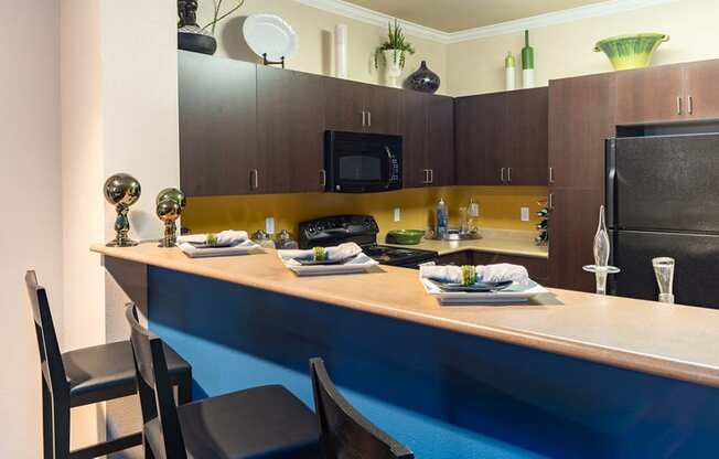 a kitchen with a long counter top and a stainless steel refrigerator