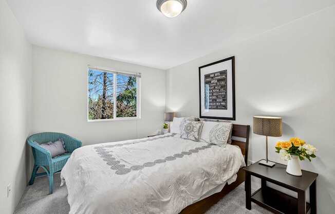 A bedroom with a large bed and a blue chair.