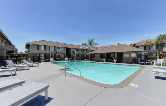 Chardonnay Ridge outdoor swimming pool surrounded by concrete sundeck. Lounge chairs spread out.