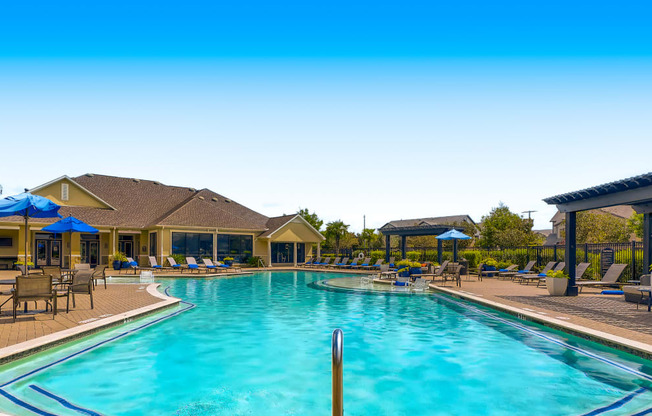 a swimming pool with chairs and umbrellas at the club house