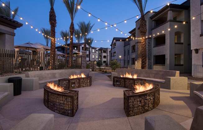 a patio with fire pits and string lights