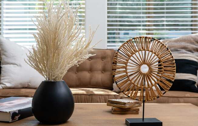 a living room with a table with a vase of wheat on it