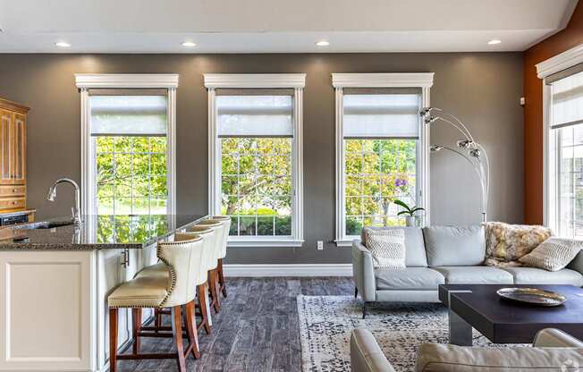 A well-lit, modern kitchen with a bar area and a seating area.