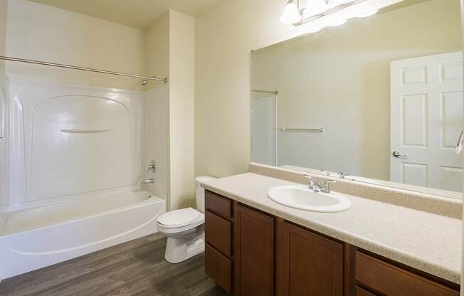 A white bathroom with a toilet, sink, and bathtub.