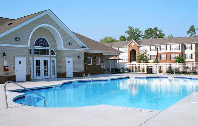 A large swimming pool in front of a building with a red sign on it.