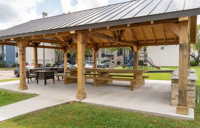 a pavilion with benches and a picnic table