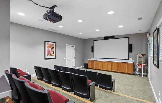 A conference room with a projector screen and chairs.