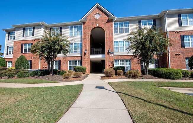 A red brick building with a walkway leading to the entrance.