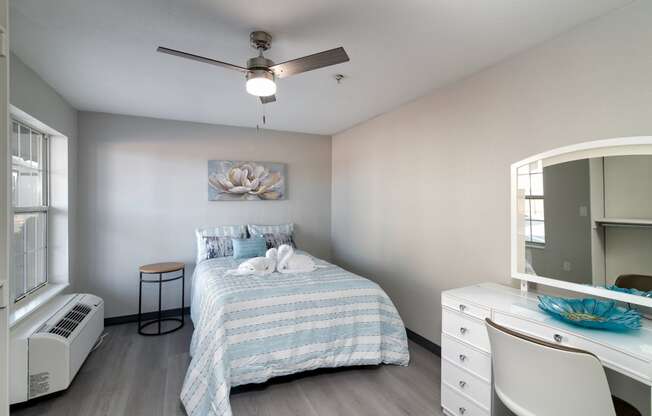 a bedroom with a bed and a ceiling fan
