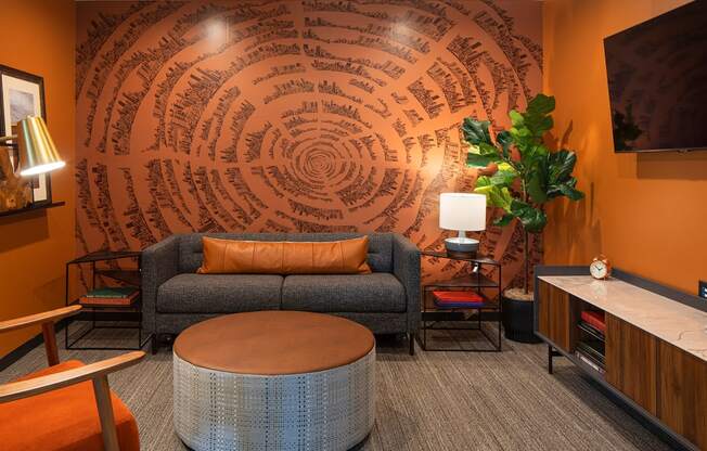 a living room with orange walls and a gray couch