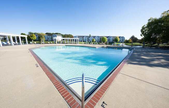 A large swimming pool with a red brick border.