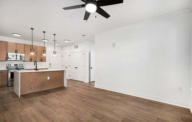 A kitchen with wooden floors and a ceiling fan.