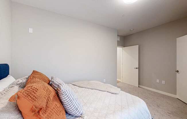 a bedroom with grey walls and a white bed