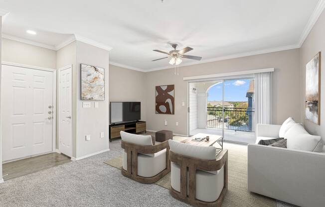 a living room with white furniture and a ceiling fan