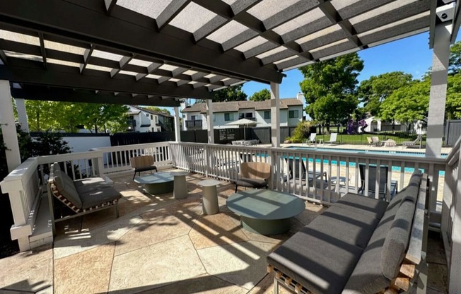 a view of the pool from a patio with chairs and awning