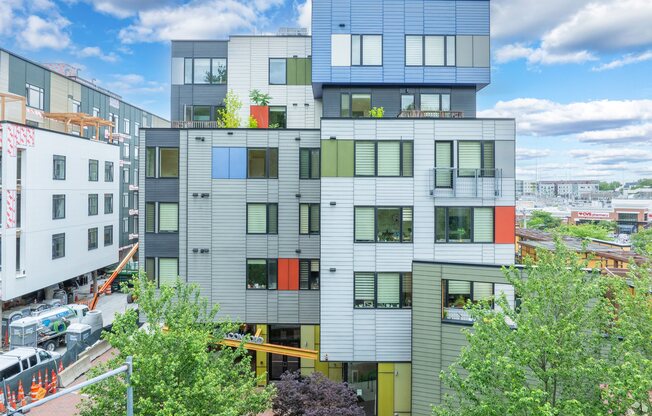 A modern multi-story building with a mix of grey, white, and orange panels. at 603 Concord Apartments, Cambridge 02138