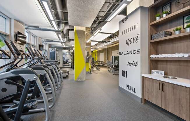 a room filled with cardio equipment and chairs in a gym