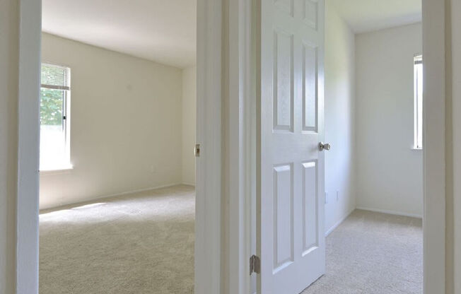 an empty bedroom with a white door and carpet