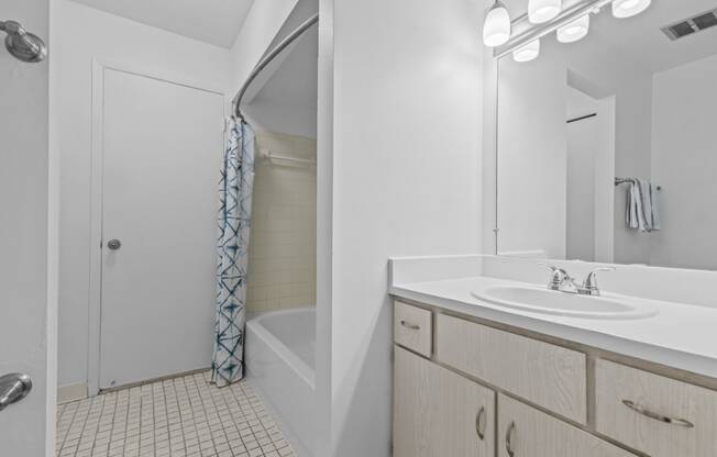 a bathroom with a shower and a sink and a mirror at Edge At Farmington Hills - Farmington Hills, MI, Michigan