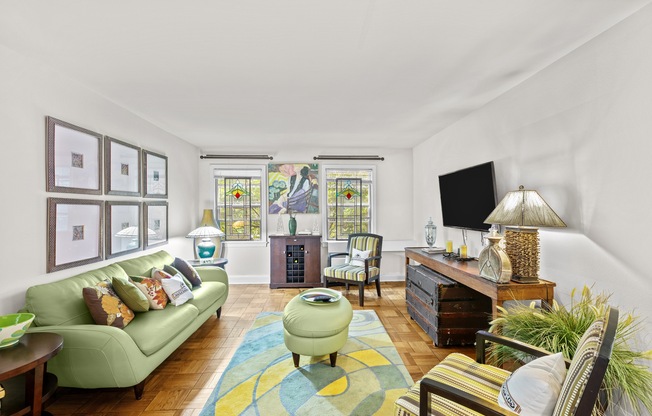 a living room with a green couch and a television