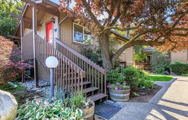 a red door on a building with a tree in front of it at Lincoln Village Apartments, Washington