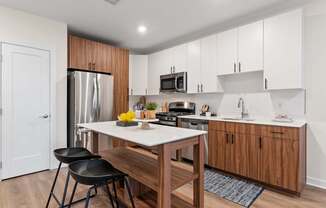 A kitchen with a table and chairs in front of a refrigerator.
