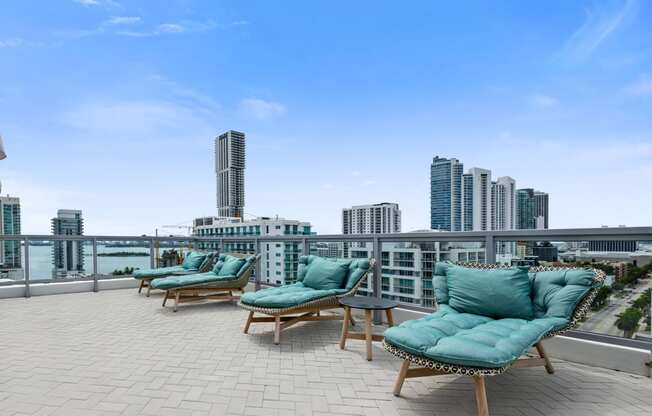 an outdoor terrace with lounge chairs and a view of the city