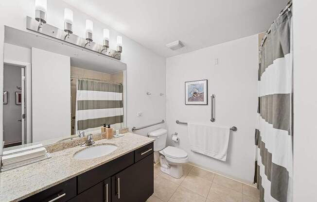 A bathroom with a sink, toilet, and a shower.