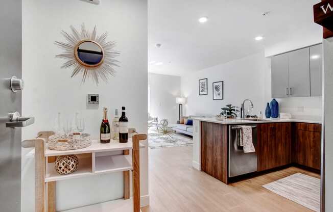 a living room and a kitchen with a bar and a mirror