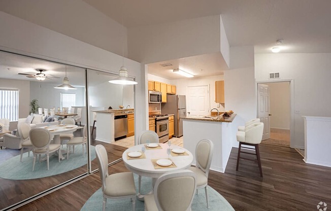 a dining room and kitchen with a table and chairs