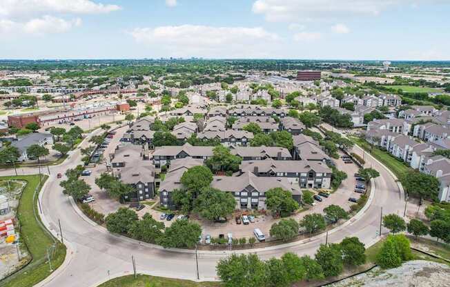 A large roundabout in the middle of a city with buildings and cars.