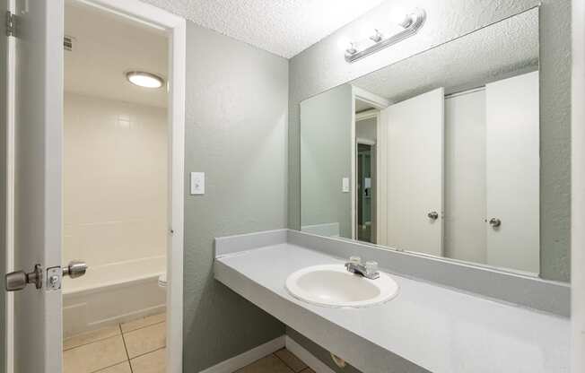 a bathroom with a sink and a bathtub at Bella Mar Apartments