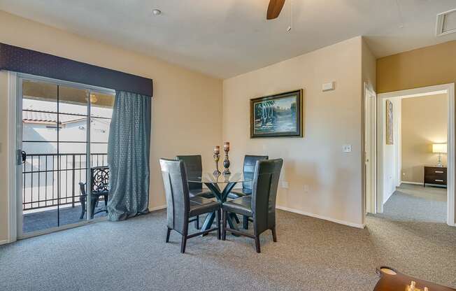 a dining room with a glass table and chairs and a balcony