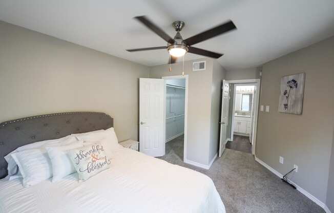 a bedroom with a bed and a ceiling fan