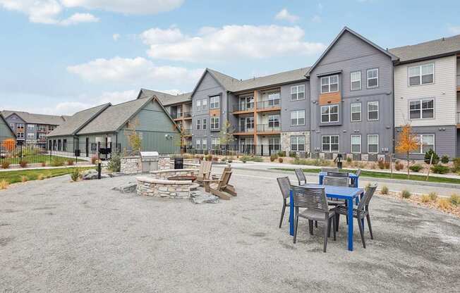 a patio with a table and chairs in front of an apartment building