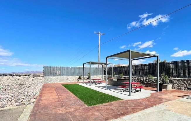A picnic area with a table and chairs under a shelter.