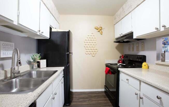 A kitchen with black appliances and white cabinets.