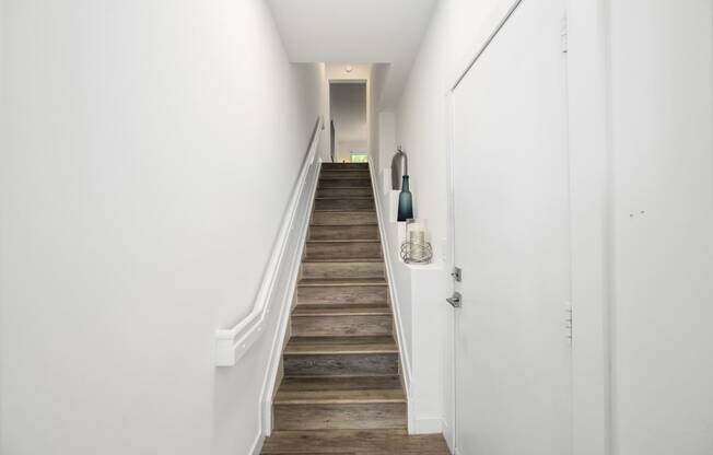 a staircase with wooden floors and white walls in a home