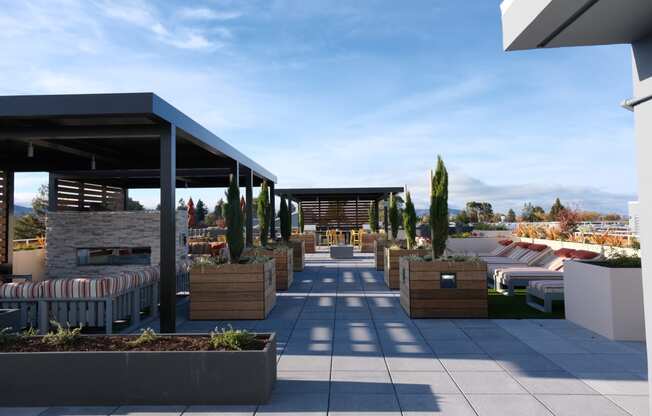Rooftop Patio Lounge With Louge Seating, Potted Plants, Fire Pit, And Grilling Area. at Bayswater Apartments, Burlingame