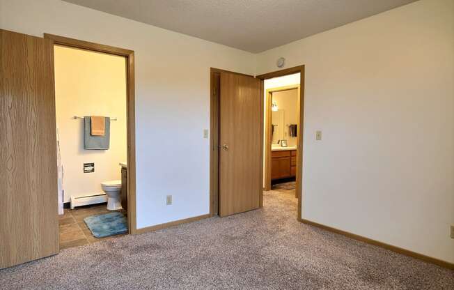 Bedroom with a bathroom attached and a closet at Parkwest Gardens West Fargo