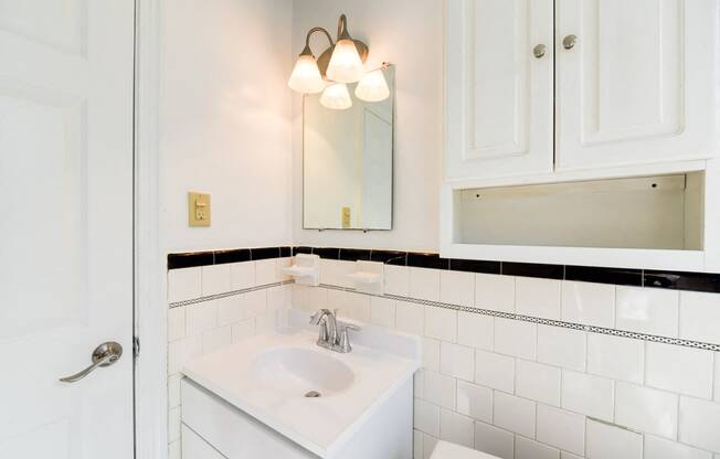 bathroom with cabinet, vanity, sink and mirror at 3101 Pennsylvania apartments in washington dc