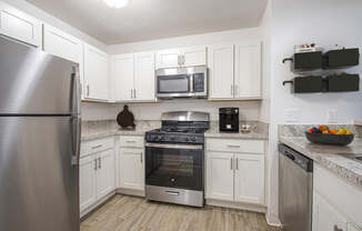 A kitchen with white cabinets and a stainless steel appliances at North Pointe Apartments, Elkhart
