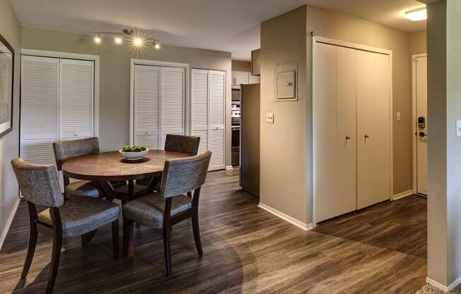 a dining room with a table and chairs and a hallway with closets