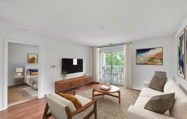 a living room with a couch and a tv and a sliding glass door at Sanger Place, Lorton, VA
