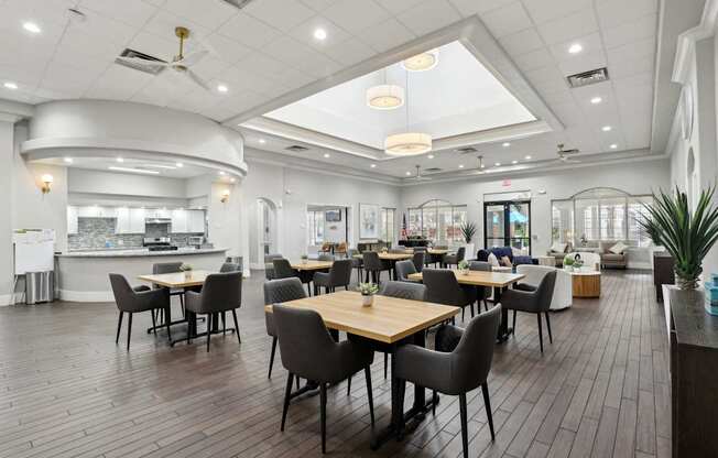 A restaurant with wooden tables and chairs and a skylight.